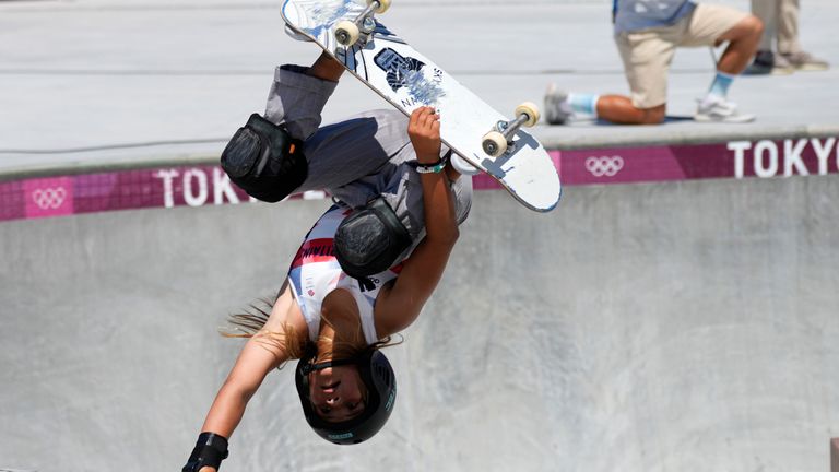 Une athlète en pleine figure acrobatique d'une compétition de skateboard